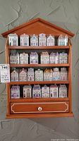 Front view of wooden rack filled with 24 ceramic house spice containers