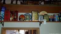 Full view of shelf with all vintage tins and bottles showing different brands and designs.
