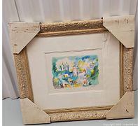 Frontal view of framed lithograph showing vibrant French street scene by Charles Cobelle with protective corner covers on frame.