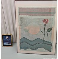 Photo showing both the large Illusion I print and the smaller Sunset Beachfront print side by side for scale, highlighting their relative sizes and frame conditions.