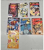 Photo showing all 7 comics laid out on a flat surface: Star Wars Adventures, Mickey Mouse, Man of War vs Rocket Ranger, Avengers, Robin, Sin City, and Dragon.