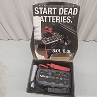 Open box showing NOCO Boost HD GB70 jump starter with clamps inside and accompanying manual and pouch