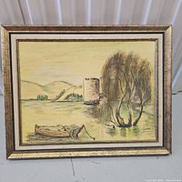 Framed painting showing a water scene with a canoe, trees, and background hills with faint yellow sky, signed by Rose Gordon in bottom right corner.