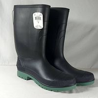 side view of both boots showing tag, toe cap texture and green soles