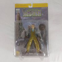 Front view of sealed DC Direct Golden Age Sandman action figure in package with accessories