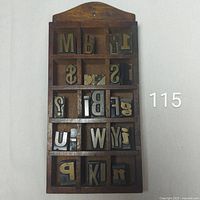 Full view of wooden shelf with metal stamps in cubbies