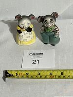 Pair of ceramic anthropomorphic mouse salt and pepper shakers sitting on a white surface with a measuring tape below showing approximately 3 inches tall.