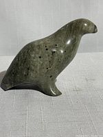 Side view showing smooth, polished stone surface with natural inclusions and seal profile.