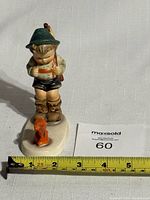 Front view of the 5 inch Goebel Hummel figurine Timid Hunter with measuring tape showing height