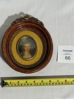 Full view of vintage oval wood frame with ornate floral top, gold velvet matting, and oval portrait of a countess in historical attire.