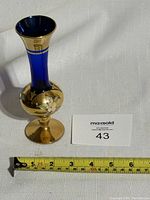 Photo of the cobalt blue glass bud vase with gold floral design and measuring tape showing height around 6 inches