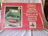 Original red box of the Coleman Tourist Easi-Lite camp stove with product photo and bilingual text.