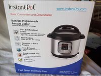 Box of Instant Pot Duo50 7-in-1 multi-functional cooker showing features and model information.