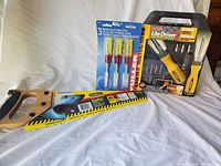 Full view of all three tools including the handsaw with wooden handle, Fuller 3-piece chisel set in original packaging, and Bossman Lite Driver screwdriver kit in closed black case.