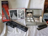 Photo showing all items in lot including surge protector, Christmas cards, cash box, calculator, and stapler