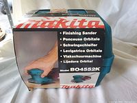 Packaging box of Makita finishing sander, showing model BO4552K and various translations of 'finishing sander'.