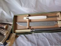 Set of two vintage Sheffield carving sets with knives and sharpening steels inside boxes on fabric background.