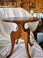 Side view showing carved legs and overall shape of vintage solid walnut wood side table.