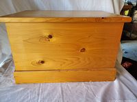 Closed wooden storage box showing natural wood grain and knots.