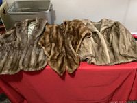 Three mink fur items laid out on a table showing the two stoles and jacket.