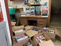 View of multiple cardboard boxes filled with puzzle boxes arranged upright and stacked, showing various puzzle images and brands.