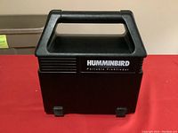 Closed black Humminbird portable fishfinder case with handle.