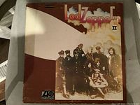 Front cover of Led Zeppelin II vinyl LP album showing band members and artwork with wear.