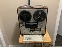 Front view of Sony TC-399 tapecorder on table with two reels mounted and manual bagged beneath