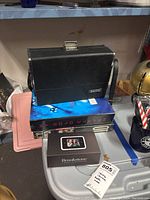 Black Sankyo retro camera in carrying case on top of two photography books and the Brookstone digital pocket pix manual near the lot tag