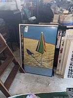 David Hockney framed retrospective poster showing beach umbrella and shadow on sand with exhibit information.