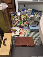 Full view of Galactic Multimac boxed game, chess set, maze and puzzle books, dry erase board, rummy board game and carrying case arranged on floor