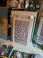 Photo showing framed nautical shell print along with other prints wrapped and stacked