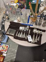 Overview of the silverware set laid out on the table showing forks, spoons, and cutlery with wooden handles.