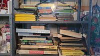Shelves containing various board games, books, and National Geographic magazines in stacks and lined up.