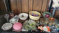 Wide shot showing the overall assortment of glass and ceramic items including hobnail glass, ceramic dishes, stemmed glasses, and Pyrex bowl.