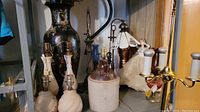 Photo showing various untested lamps including ceramic and metal bases, along with a large decorative vase and a stoneware jug.