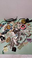 Overview of the lot showing belts, jewelry, and hair accessories spread out on a surface.