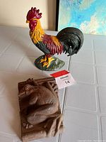 Photo of the cast iron rooster door stop and cast iron frog placed on a table.
