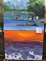 Photo of two original acrylic paintings on 16x20 canvases, one with a lakeside scene with houses on stilts, mountains, and greenery; the other with an orange and purple abstract or natural scene.