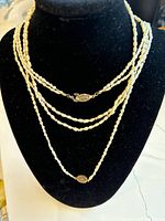 Set of three freshwater pearl necklaces displayed on a black jewelry bust showing the size and layering with visible sterling silver clasps.