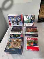 Six puzzle boxes arranged on a table showing titles and piece counts.