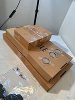 Three cardboard boxes stacked with three round plastic coin rings taped on top