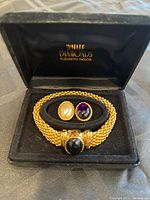 Photo of the bracelet in box featuring pearl and amethyst interchangeable clasps.