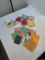 White ceramic electric scent melter with plug, six wax melts in various scents and colors, ten assorted patterned wax wraps with floral and geometric designs