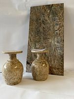 Photo showing two marble egg holders and one rectangular marble slab tray with natural brown and caramel marble tones.