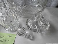 Close up image showing crystal decanter lid and stopper with part of large bowl and candle holders