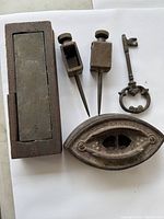 Top view of the lot showing iron sharpening tool, two brass sharpening tools, vintage skeleton key, and wooden box.