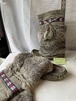 Pair of gray vintage moccasins with fur exterior, cotton canvas lining, size ruler visible