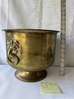 Photo of the vintage light brass bucket showing the full height approximately 10 inches with warm patina and surface wear.