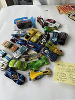 Overview of 23 diecast cars mostly Hot Wheels, showing various designs, colors and conditions including packaged and loose cars.